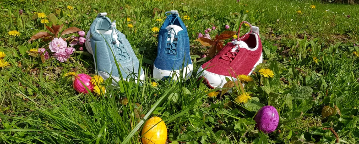 three assorted-color sneakers on grass