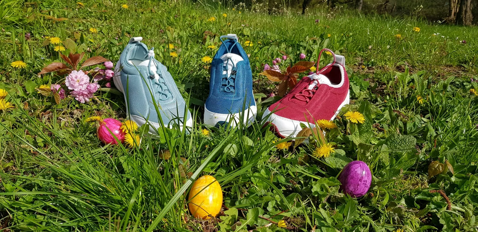 three assorted-color sneakers on grass