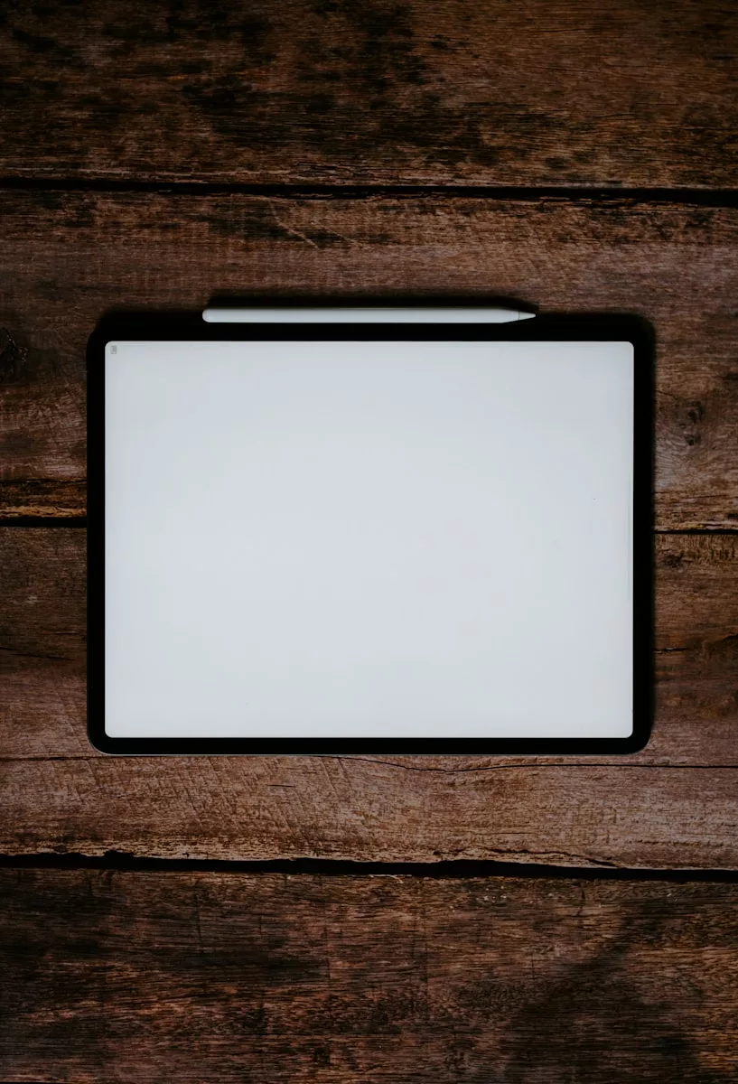 white and black tablet computer on brown wooden table