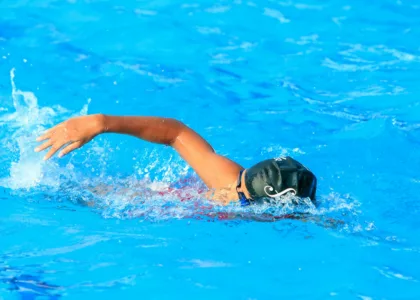 a person swimming in a pool with blue water