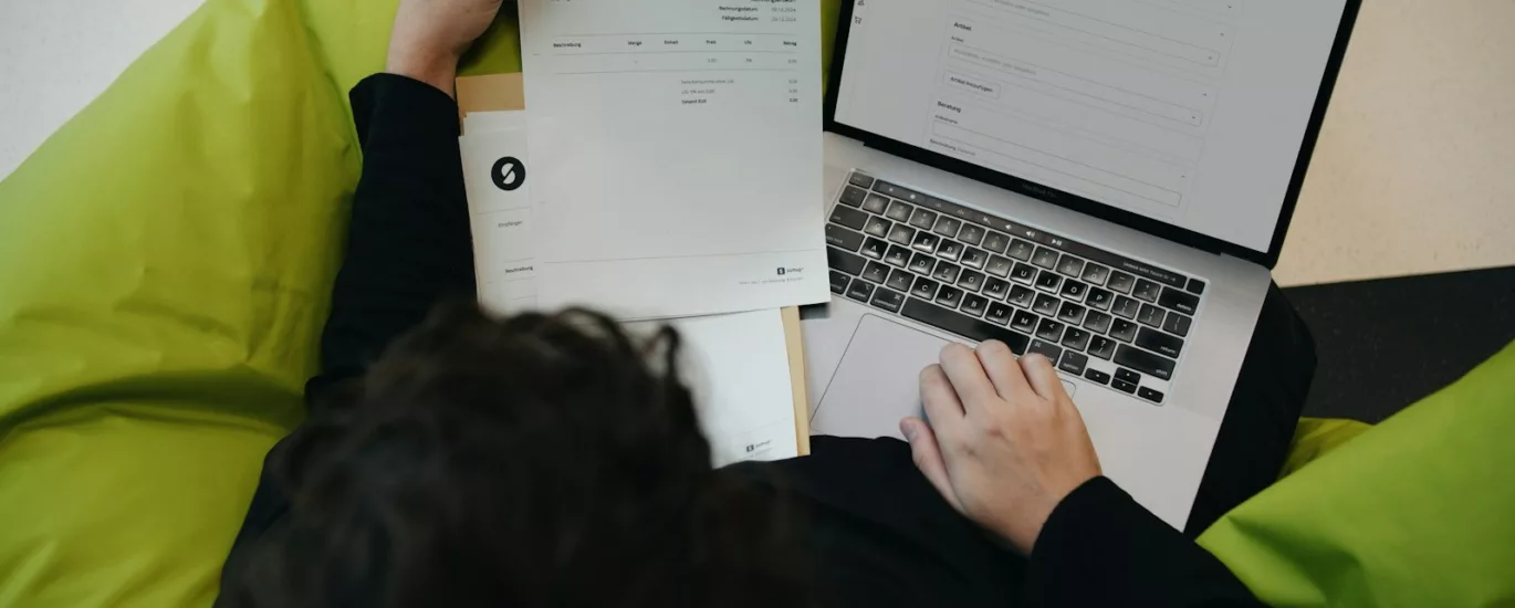 A person sitting on a bean bag chair working on a laptop