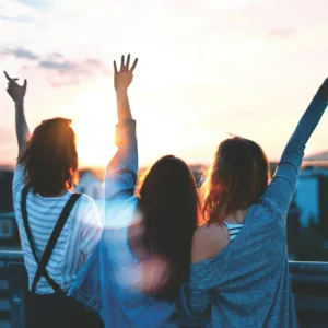 photo of three women lifting there hands 
