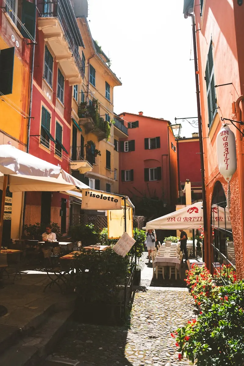 Colorful buildings line a narrow street with outdoor cafes.